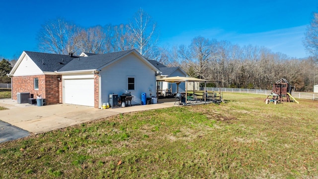 view of property exterior with a lawn, central air condition unit, and a garage