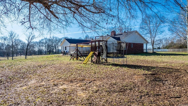 view of yard featuring a playground and a trampoline