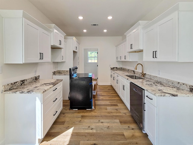 kitchen with stove, light wood-type flooring, sink, dishwasher, and white cabinetry