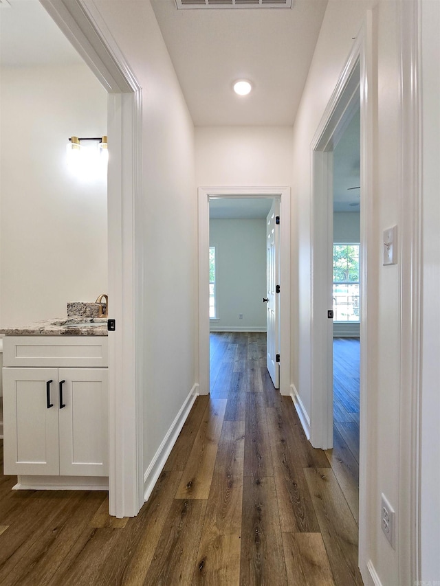 hallway with dark hardwood / wood-style flooring and sink