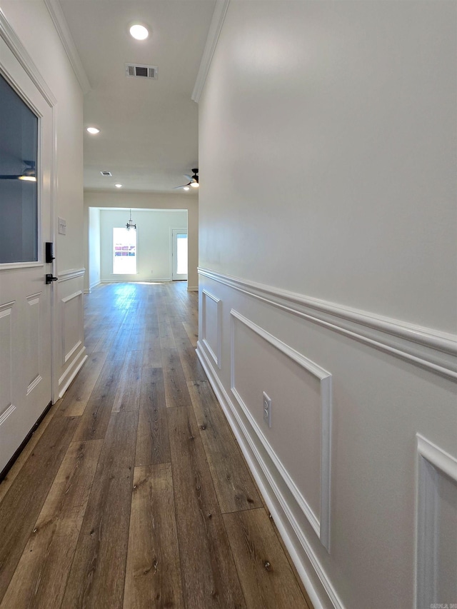 hall with dark hardwood / wood-style floors and ornamental molding