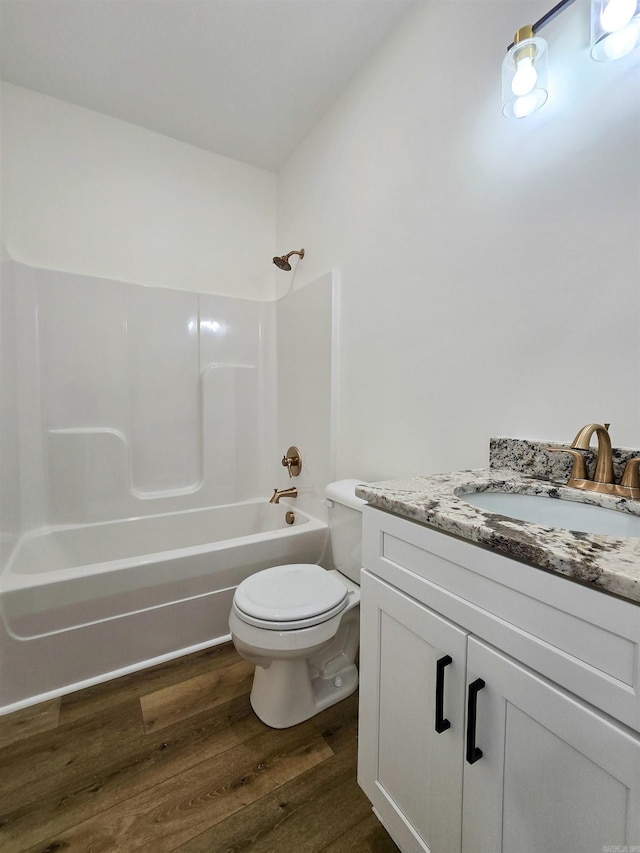 full bathroom with hardwood / wood-style flooring, vanity, toilet, and tub / shower combination