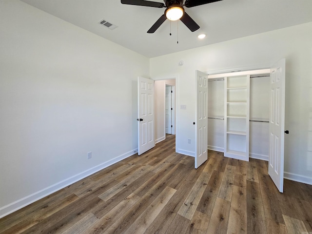 unfurnished bedroom featuring ceiling fan, a closet, and dark wood-type flooring