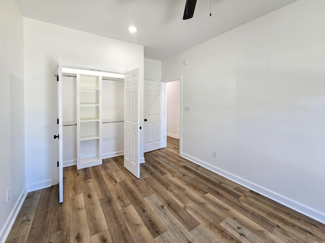 unfurnished bedroom with dark hardwood / wood-style flooring, ceiling fan, and a closet