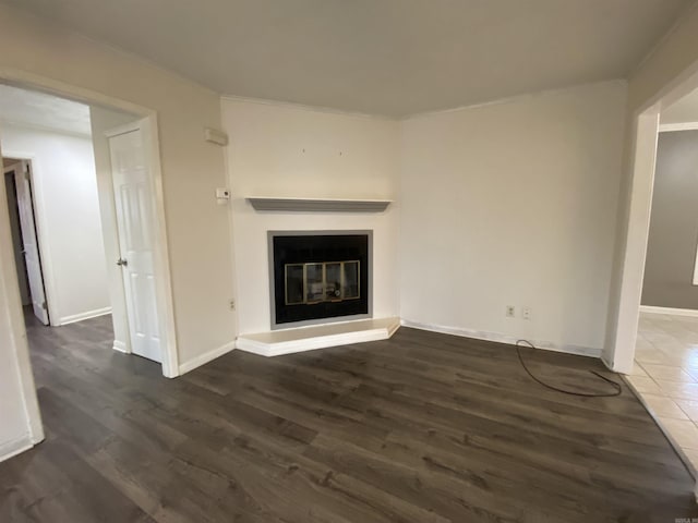 unfurnished living room with dark hardwood / wood-style flooring and ornamental molding