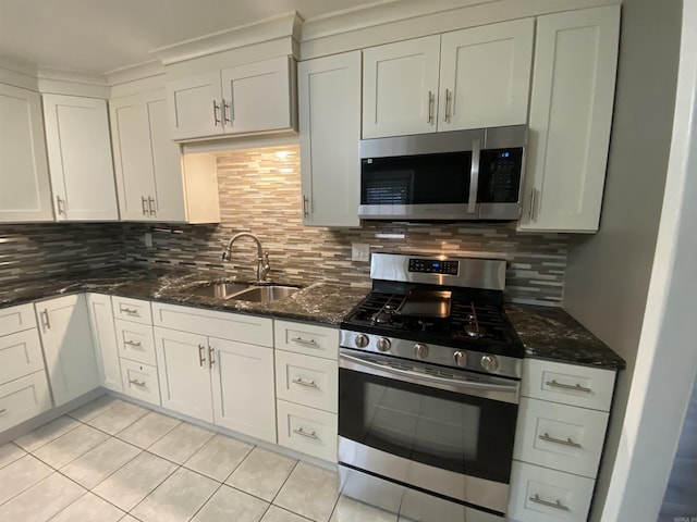 kitchen with white cabinets, stainless steel appliances, tasteful backsplash, and sink