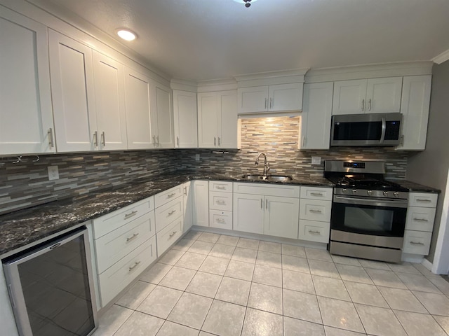 kitchen featuring sink, beverage cooler, stainless steel appliances, tasteful backsplash, and white cabinets