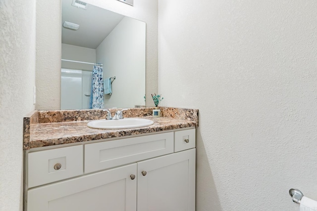 bathroom featuring vanity and curtained shower