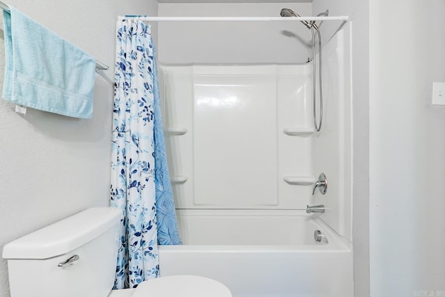 bathroom featuring shower / bath combination with curtain and toilet