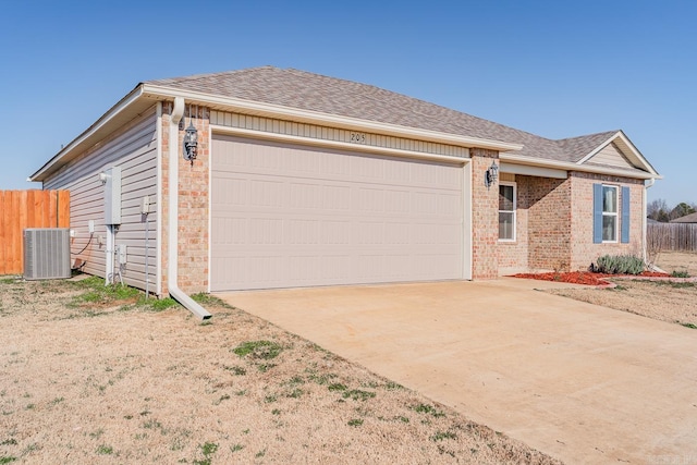 ranch-style home with central AC unit and a garage