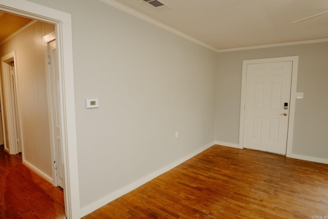 spare room featuring hardwood / wood-style flooring and ornamental molding