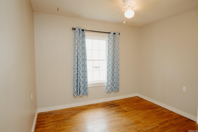 spare room featuring plenty of natural light, ceiling fan, and wood-type flooring