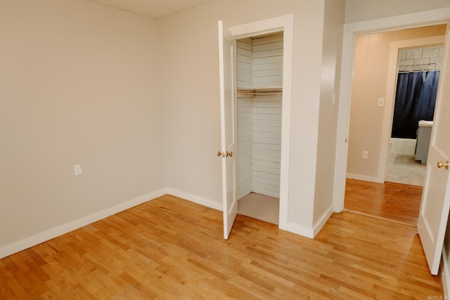 unfurnished bedroom featuring a closet and light hardwood / wood-style flooring