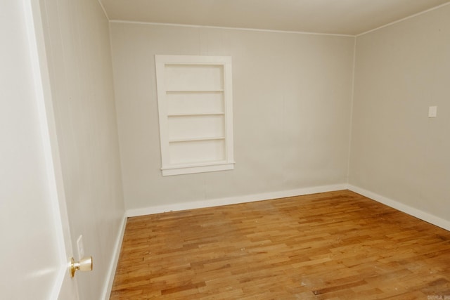 empty room with built in features and wood-type flooring