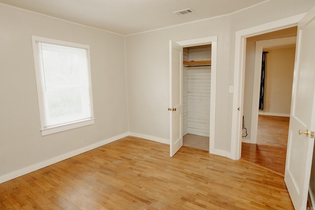 unfurnished bedroom with a closet and light wood-type flooring