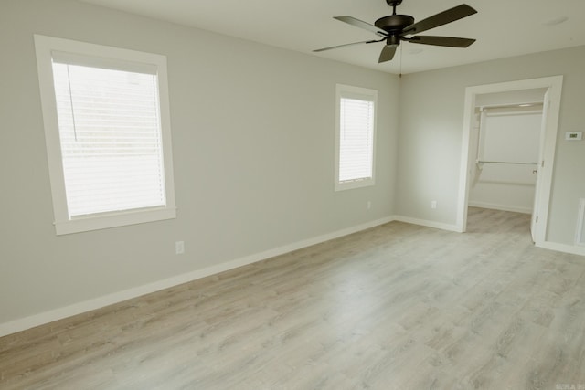 unfurnished bedroom featuring a walk in closet, ceiling fan, a closet, and light hardwood / wood-style floors