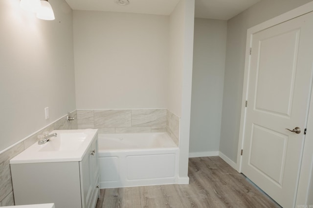 bathroom with a washtub, vanity, and hardwood / wood-style flooring