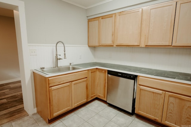 kitchen with tile countertops, dishwasher, light tile patterned floors, and sink