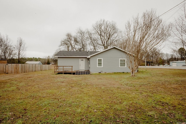 rear view of property with a deck and a yard