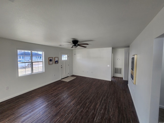 unfurnished living room featuring a textured ceiling, dark hardwood / wood-style flooring, and ceiling fan