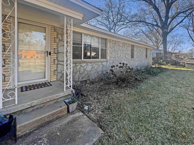 entrance to property featuring a yard