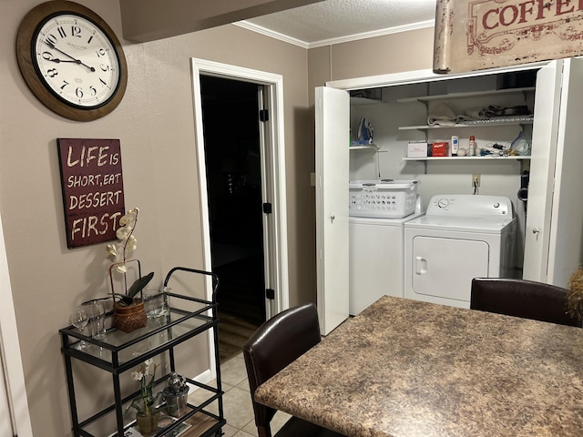 washroom featuring tile patterned floors, ornamental molding, washer and dryer, and a textured ceiling