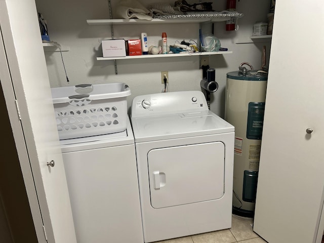 laundry room with washing machine and clothes dryer, water heater, and light tile patterned floors