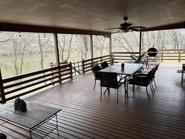 wooden deck with a water view and ceiling fan