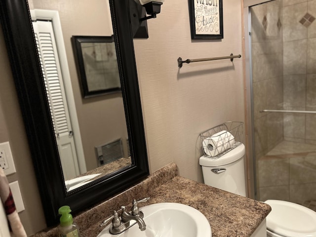 bathroom featuring vanity, a shower with door, and toilet