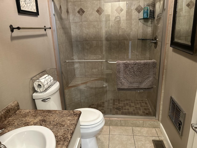 bathroom featuring a shower with door, vanity, tile patterned flooring, and toilet