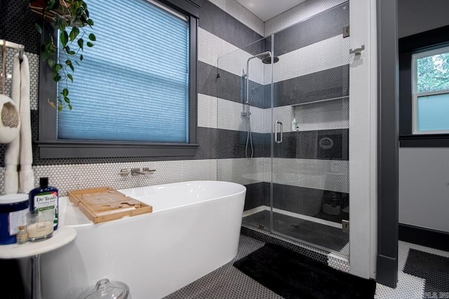 bathroom featuring tile patterned flooring, shower with separate bathtub, and backsplash