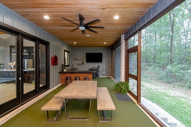 sunroom / solarium featuring ceiling fan and wooden ceiling