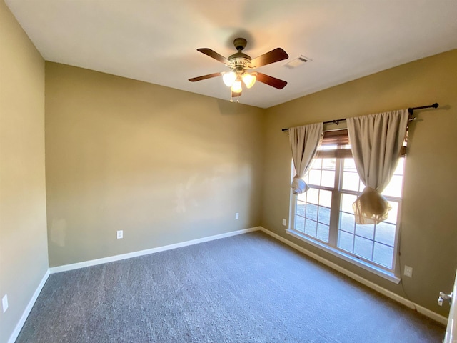 spare room featuring ceiling fan and carpet