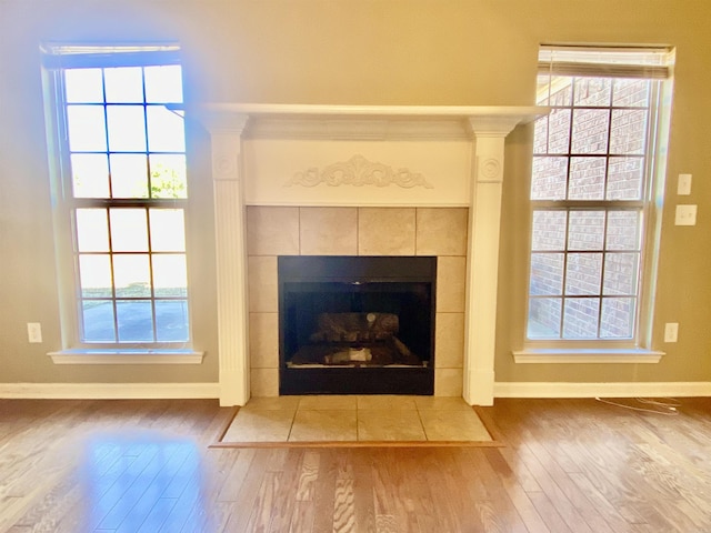 interior details with a tile fireplace and hardwood / wood-style flooring