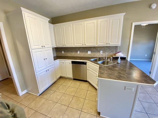 kitchen featuring dishwasher, sink, tasteful backsplash, kitchen peninsula, and white cabinets