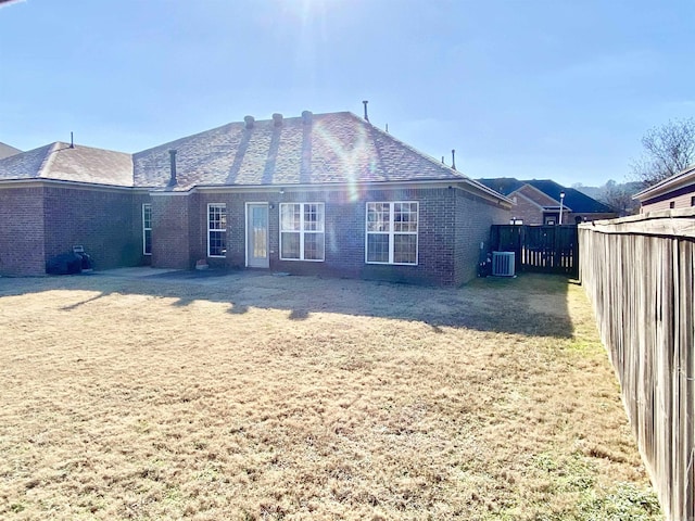 back of house featuring a yard and central AC unit