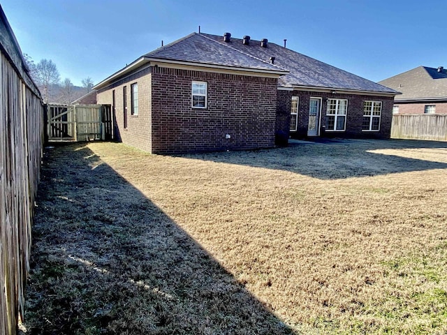 rear view of property featuring a lawn