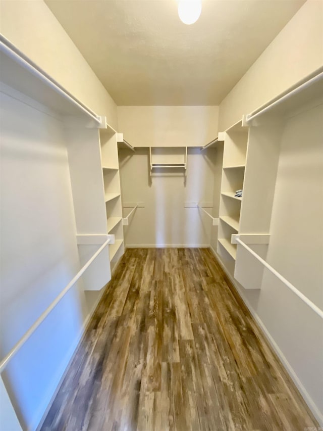 spacious closet with dark hardwood / wood-style flooring