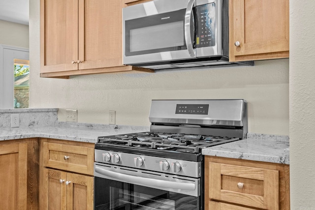 kitchen featuring light stone countertops and appliances with stainless steel finishes