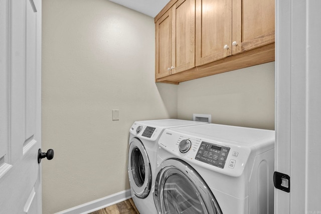 laundry room featuring separate washer and dryer, cabinets, and hardwood / wood-style flooring