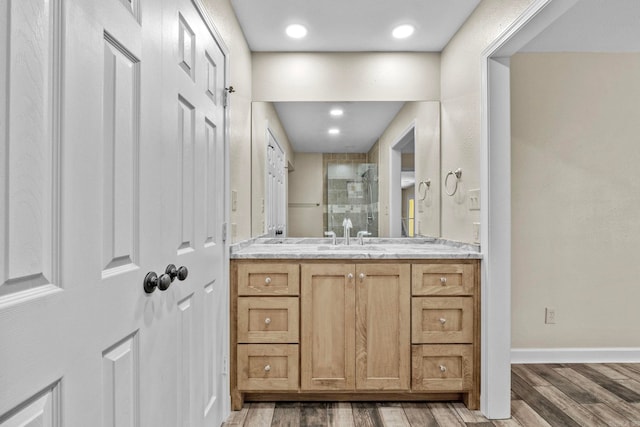 bathroom with a shower, hardwood / wood-style floors, and vanity