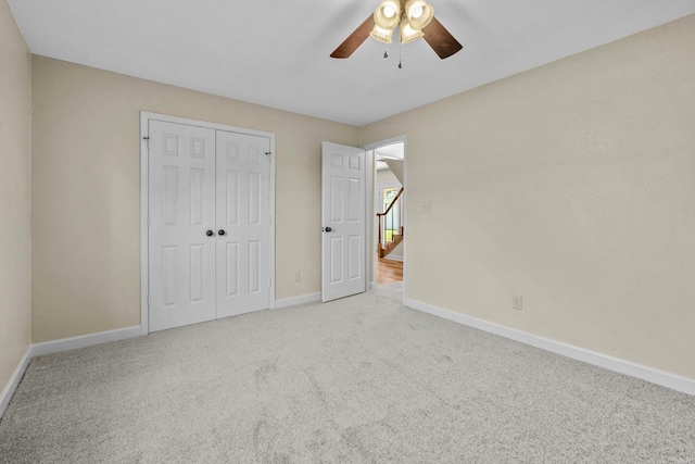 unfurnished bedroom featuring carpet flooring, ceiling fan, and a closet