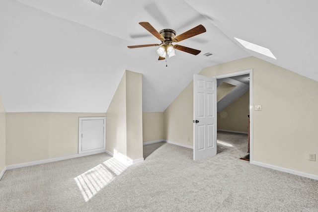 additional living space featuring ceiling fan, vaulted ceiling with skylight, and light carpet