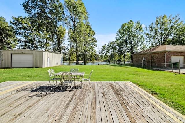 wooden deck featuring an outbuilding, a yard, a water view, and a garage