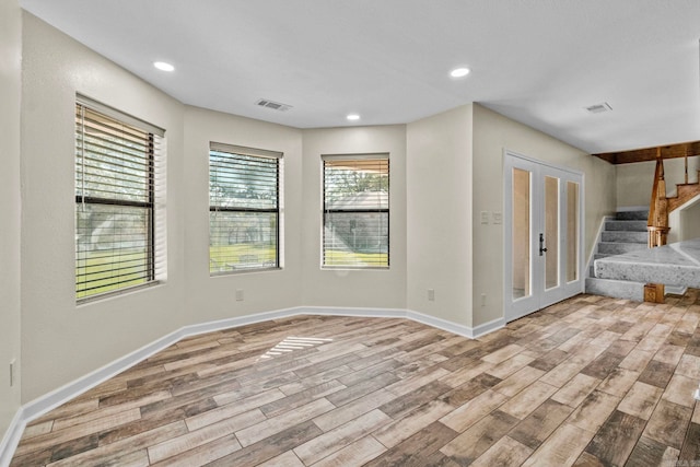 empty room with french doors and light wood-type flooring