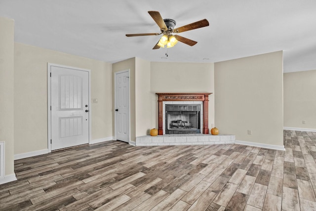 unfurnished living room with ceiling fan and wood-type flooring