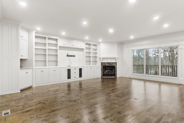 unfurnished living room with dark hardwood / wood-style flooring, a fireplace, and ornamental molding