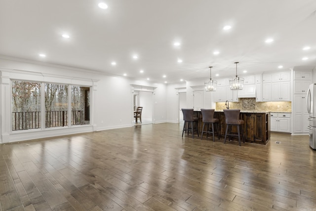 interior space with dark hardwood / wood-style floors, ornamental molding, and sink