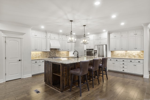 kitchen with white cabinets, sink, hanging light fixtures, a large island, and stainless steel appliances