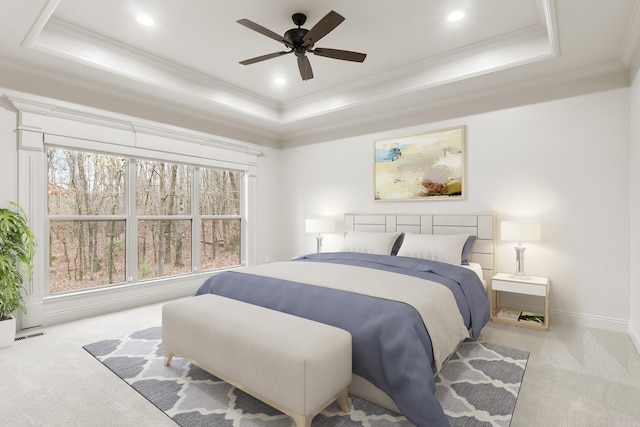 bedroom with a tray ceiling, ceiling fan, crown molding, and light carpet